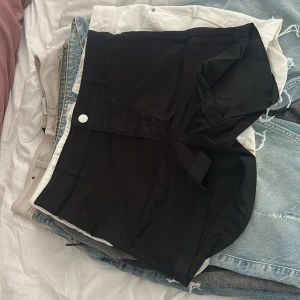 Svarta jeansshorts - Svarta shorts. Deser ut att vara tillverkade i bomull eller ett liknande material. 