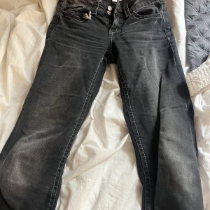 Svarta/gråa jeans från Gina Tricot - Snygga mörk gråa jeans från Gina Tricot i storlek 158. Jeansen har en klassisk femficksmodell, tydliga vita sömmar och en lätt tvättad look. Säljer eftersom de är förkorta för mig.