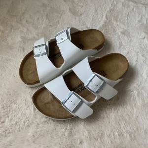 Birkenstock Arizona vita - Säljer mina vita birkenstock Arizona i storlek 37.  Dem är endast använda en gång men var alldeles för stora för mig. Nypris 950kr Säljer för 700kr