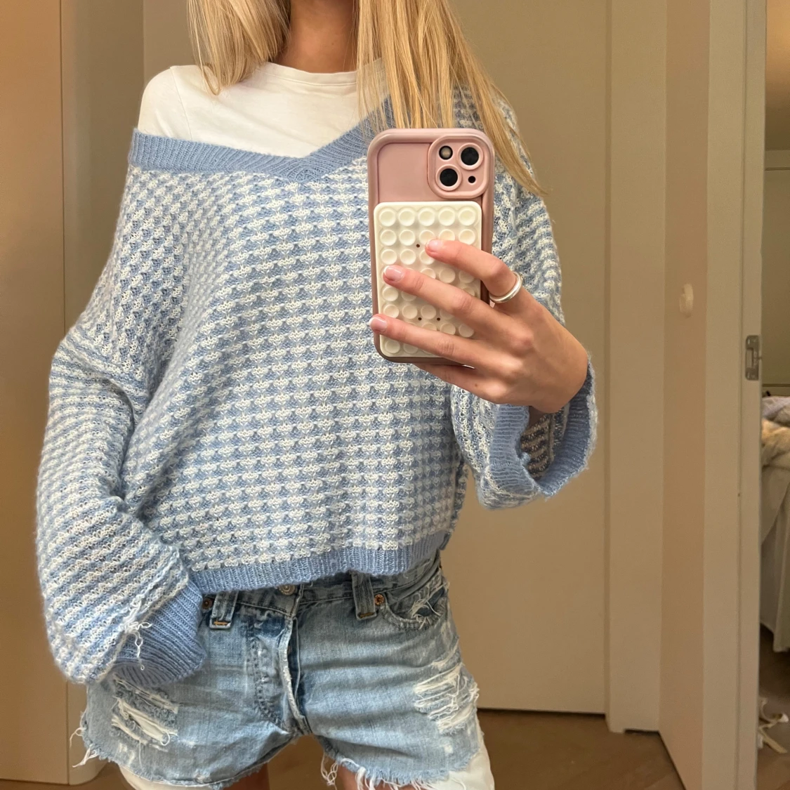 Ljusblå och vit stickad v-ringad tröja