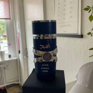 Parfym - Lattafa Asad Zanzibar är en parfym i en mörkblå flaska med silverdetaljer och orientaliska mönster. Flaskan har en robust, modern design med arabiska tecken och ett dekorativt emblem. Kommer i matchande blå kartong med silvertryck. Har sprayat typ 5 sprut med flaskan så den är nästan helt ny. 