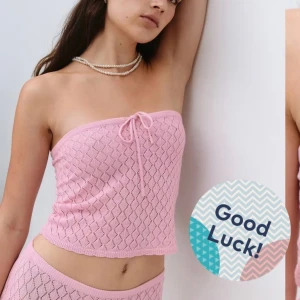 Ljusrosa stickad bandeau tubtopp - Supersöt ljusrosa stickad bandeau tubtopp med hålmönster och en liten knytning framtill. Perfekt för varma dagar och ger en riktigt trendig vibe.