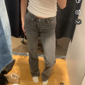 Grå bootcut jeans midwaist - Säljer ett par gråa jeans med bootcut-modell och hög midja. Jeansen har klassisk femficksdesign, knapp- och dragkedjestängning samt raka ben som blir vidare nertill. Perfekta för en chill och snygg look.