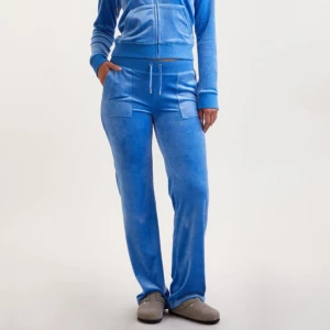 Blå Juicy Couture byxor - Blåa mjukisbyxor från Juicy Couture i mjuk velour. Byxorna har tyyvär tappar en av metallsakerna på byxbandet därför säljer jag byxorna lite billigare! 