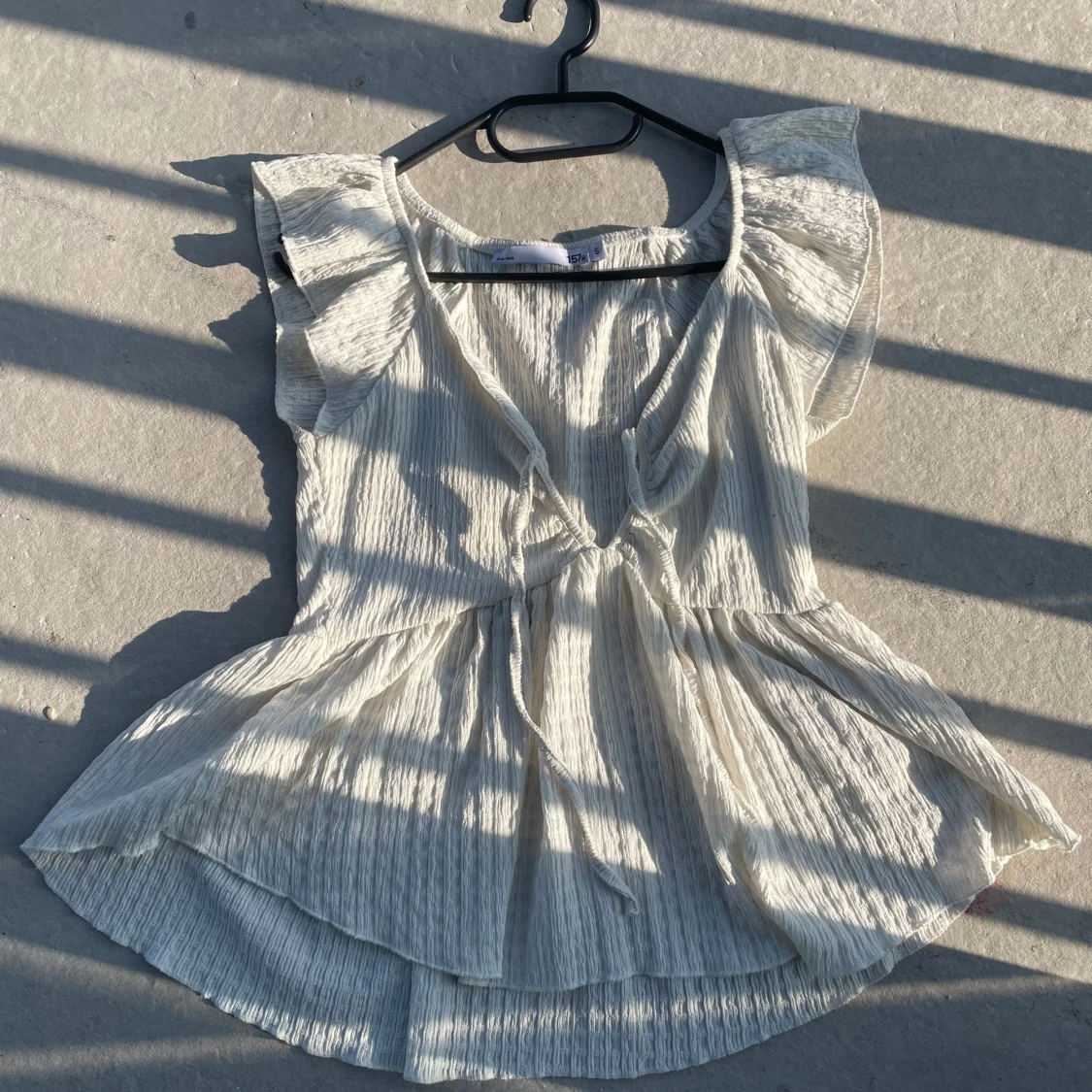 Vit blus med volangärm och knyt