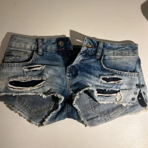 Rippade jeansshorts från Mohito - Snygga ljusblå jeansshorts från Mohito med slitna detaljer, stora hål och fransig kant. Det störningar dem att det är strl 34 men skulle snarare säga 32💕💕💕