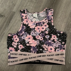 Blommig sportig linnetopp - Superfin linnetopp från Lindex med blommigt och leopardmönster i rosa, lila och svart. Resår nertill med texten 'RUN FAST - JUMP HIGH' ger en sportig vibe. Perfekt för träning eller när du vill sticka ut lite extra. Jag skulle säga att den passar om man andvänder XXS eller XS!