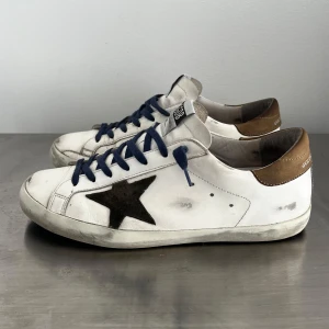 Golden Goose skor  - Säljer ett par riktigt schyssta Golden Goose skor i storlek 42. Fint skick, se bilder. Nypris 4999kr, köp för endast 2399kr. Färgen vit med olivgrön stjärna, riktigt snygga! Dustbag medföljer. Möts upp i Stockholm eller frakt. 