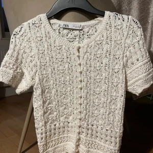 Zara stickad blus - Supersöt vit stickad blus från Zara med korta ärmar. Säljer då den inte kommer till användning. Endast använd 1 gång. Inga defekter. Köptes för 400kr. Finns ej att köpa längre.