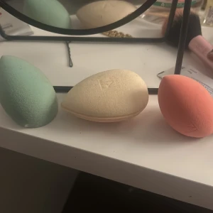 3-pack RT beautyblenders i olika färger - Säljer tre mjuka beautyblenders från Real Techniques i färgerna mintgrön, beige och korall. De har en droppformad design som gör det enkelt att applicera foundation, concealer eller puder. Perfekta för att få till en flawless bas och blanda ut smink jämnt.
