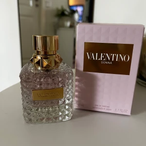 Valentino Donna Eau de Parfum 50ml - Lyxig parfym från Valentino i en elegant, prismad glasflaska med guldiga detaljer och nitar. Doften är blommig och orientalisk med noter av bergamott, orrisrot och vanilj. Perfymen har aldrig används då doften inte riktigt passade mig, så den är i absolut nyskick. Nypris var 1400 kr, och jag säljer den för minst 900 då den är helt ny. 🥰