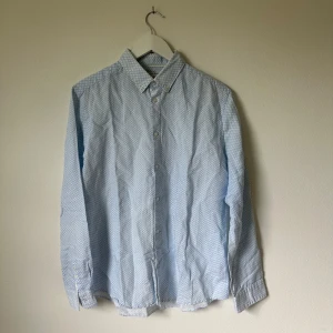 Ljusblå Esprit skjorta med mönster - Snygg ljusblå skjorta från Esprit med diskret mönster i blått. Slim fit-modell med klassisk krage och knappar framtill. Tillverkad i en skön mix av linne och bomull som ger en luftig känsla. Perfekt för dig som gillar stilrena detaljer och en fräsch look. Artnr: B360