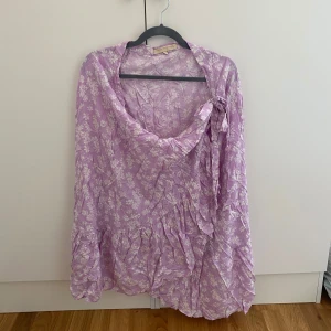 Lila blommig omlott kjol, Pernilla Wahlgren - Superfin lila omlott kjol från Pernilla Wahlgren med vitt blommönster. Perfekt för sommarens alla tillfällen när du vill känna dig extra söt och trendig. Kan mötas upp i Trollhättan eller Alingsås. Kan skickas men då tillkommer en fraktkostnad.