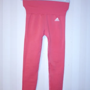 Rosa Aeroknit leggings från Adidas XS - Säljer ett par snygga rosa Aeroknit leggings från Adidas i storlek XS. De har hög midja, tight passform och är tillverkade i ett stretchigt syntetmaterial som andas. Perfekta för träning eller chill dagar. Adidas-logga på höften och diskret mönster längs benen. Kan skickas med extra pris via post.