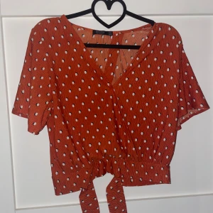 Prickig omlottblus från Bershka - Superfin orange omlottblus från Bershka med vita prickar och knyt i midjan. 
