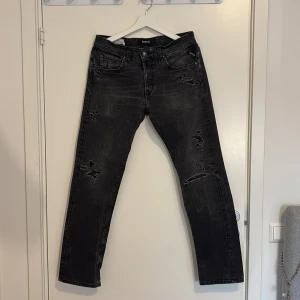 Replay Grover svarta straight jeans - Svarta Replay Grover jeans med straight fit och slitna detaljer. Jeansen har klassisk femficksdesign, snygg tvätt och coola slitningar på benen. Tillverkade i jeansmaterial som ger en avslappnad vibe. Perfekta för dig som gillar en edgy stil.