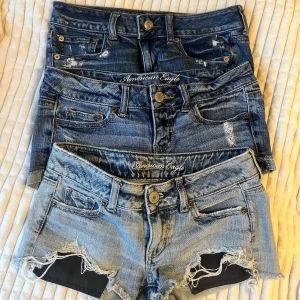 3 par jeansshorts från American Eagle - Tre par snygga jeansshorts från American Eagle. Alla har slitna detaljer och låg midja. Perfekta för sommaren med en cool, avslappnad vibe. Storlek XS. Allas pris är 150€