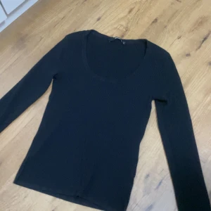 Svart ribbad tröja från BikBok - Svart långärmad tröja från BikBok med ribbad struktur och rundad, djup ringning. Snygg och enkel modell som är lätt att matcha till olika outfits. Perfekt basplagg för dig som gillar stilrena och bekväma looks