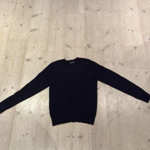 Mörkblå merinoulltröja från Riley Brothers - En stilren mörkblå (ser svart ut på bilden) tröja från Riley, brothers i 100% merinoull. 9/10,Använd 2 gånger med klassisk rund halsringning och långärmad. Perfekt för dig som gillar en clean och enkel look med premiumkänsla. Passar till allt och är superbekväm.  899 kostar den i butik.