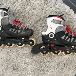 Inlines Firefly ILS 300 B Storlek 33-36 - Ett par inlines av märket Firefly, modell ILS 300 B. Storleken är justerbar mellan 33 och 36. Perfekt för barn eller ungdomar som vill åka inlines. Snygga inlines från Firefly i svart, vitt och rött med röda snören och justerbart spänne. Meshdetaljer för bra ventilation och robust plastskal för extra stöd. Perfekta för dig som vill cruisa runt i stan eller i parken.