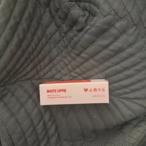 H&M Beauty Matte Lippie Ariel - Matt läppstift i färgen Ariel från H&M Beauty. Intensivt röd nyans med matt finish, formulerad med hyaluronsyra för extra återfuktning. Ej använd, inte ens testat endast öppnat förpackning för att se hur den ser ut. Säljer för 100 kr. 