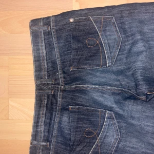 mörkblå lågmidjade jeand  - bootcut vintage jeans med snygga detaljer. Köpt från Polens second hand