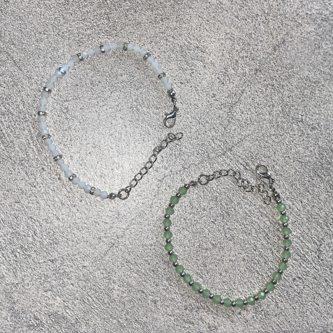 Två pärlarmband i vitt och grönt