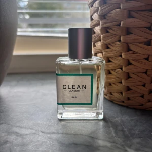 CLEAN Classic Rain parfym - Fräsch parfym från CLEAN i doften Classic Rain. Flaskan är genomskinlig med en enkel, stilren etikett och silverfärgad kork. Perfekt för dig som gillar lätta och rena dofter. Flaskan är rektangulär och gjord av glas. Ny