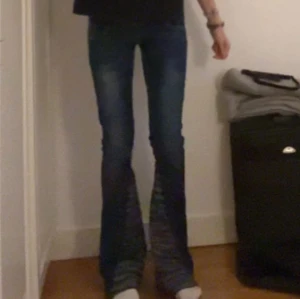 Blå bootcut jeans med zebramönster - Säljer ett par snygga blå bootcut jeans med riktigt med unika zebramönstrade detaljer på utsvängda benslut. Jeansen passar verkligen till allt!!💖storlek 34, men passar även 36!! Skriv för intresse eller fler bilder💖