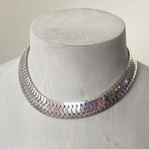 Chunky silverfärgat choker-halsband - Snyggt och chunky choker-halsband i silverfärg med bred, platt kedja som har ett coolt geometriskt mönster. Justerbar längd med kedja och lås baktill. Perfekt för att ge din outfit en edgy vibe och få dig att sticka ut.
