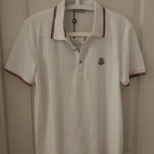 Vit Moncler pikétröja  - Vit pikétröja från Moncler med klassisk krage och korta ärmar. Hör av er vid frågor eller för fler bilder. Pris kan diskuteras 