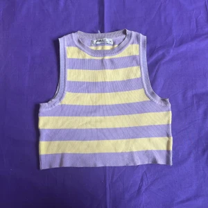 Randig linnetopp - Pastelliga komplementfärger i lila och gul. Stickat tyg, mycket stretchig. 80% viskos, 20%polyamid Knappt använd.