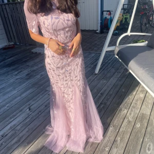 Ljuslila långklänning med glittriga detaljer - Säljer en magisk ljuslila långklänning med glittriga paljetter i ett vackert mönster. Klänningen har korta ärmar och är gjord i ett tunt material som ger en drömmig känsla. Perfekt för dig som vill ha en klänning med elegans och glitter. Lapp kvar men säljs tyvärr då jag redan hade en balklänning🥰💖