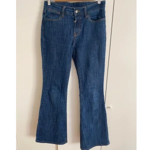 Blå bootcut jeans från Brandy Melville  - Blå bootcut jeans från Brandy Melvillie, Jeansen är low/mid-waist. Jeansen har en liten fläck från när jag köpte dem som inte går bort i tvätten och är lite söndriga längst ner på baksidan. De är one-Size men jag skulle säga att de passar storlek 36.