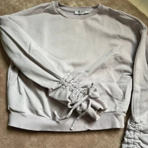 Ljuslila sweatshirt med snörning -  super skön tröja med detaljer på armarna.