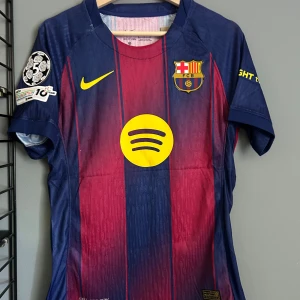 FC Barcelona Raphinha matchtröja Nike - Säljer en officiell FC Barcelona matchtröja med Raphinha 11 på ryggen. Tröjan är blå och röd med gula detaljer, klubbmärke, Nike-logga och Spotify som sponsor. Korta ärmar, randigt mönster och tillverkad i lätt funktionsmaterial. Perfekt för dig som älskar Barca! Helt ny med tagg en replika 