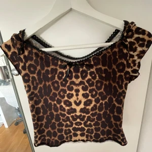 Leopardmönstrad topp med rosett - Säljer leopard topp, aldrig använt