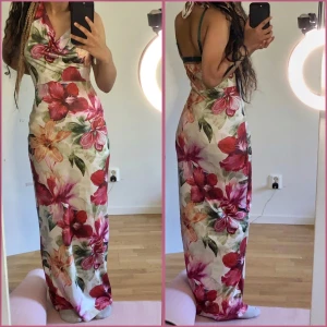 Blommig långklänning med halterneck - Säljer en superfin långklänning med halterneck och v-ringad front. Klänningen har ett färgstarkt blommigt mönster i rött, rosa, orange och grönt på vit botten. Sval och flowy passform, perfekt för varma dagar. Snyggt omlott vid halsen och öppen rygg.