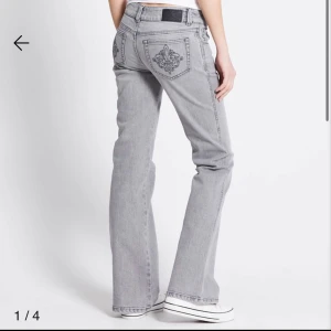 Grå bootcut jeans från 157 - Snygga grå jeans från 157 med bootcut passform och låg midja. Jeansen har coola broderade detaljer på bakfickorna och klassisk femficksdesign. Tillverkade i mjukt bomullsmaterial med en tvättad look som ger en trendig vibe.