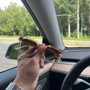  CHIMI Solglasögon - Snygga solglasögon från CHIMI med transparent, fyrkantig båge i plast och bruna tonade glas. Perfekt accessoar för att lyfta din stil med en modern och clean look. Passar dig som gillar trendiga och stilrena detaljer.