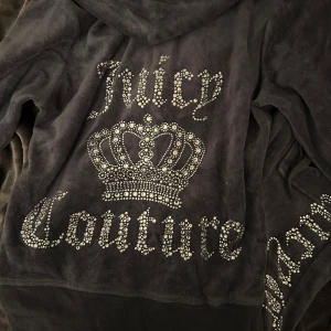 Juicy Couture set - Säljer detta Juicy Couture mjukis-set i mörkblått med glittrande strassdetaljer. Hoodien har dragkedja med J-hänge, huva och stor krona på ryggen. Byxorna har snörning i midjan och Juicy Couture-logga i strass längs benet.🤍 den är i storlek M men passar dig som har S också!