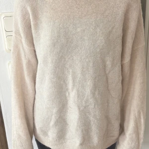 Beige stickad tröja från C - Mysig beige stickad tröja från Cubus i storlek M. Tröjan har en enkel och clean design med rund hals och långa ärmar. Perfekt för lager-på-lager och chill dagar. Materialet är mjukt och fluffigt, vilket gör den extra skön att ha på sig. Aldrig använt.