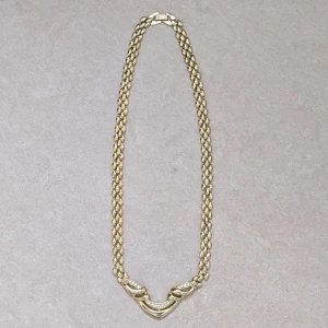 Guldigt halsband  med stenar - Säljer ett snyggt halsband i guldton. Halsbandet har en chunky kedja och ett V-format parti med små glittrande stenar. Perfekt för dig som gillar statement-smycken med lyxig känsla. Låsningen är robust och detaljerna är riktigt stilrena.