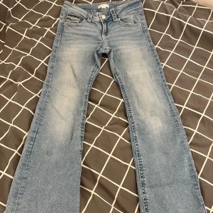 Blå bootcut jeans från Gina Young  - Snygga ljusblå jeans från Gina Young i storlek 158 i tall. Modellen har klassisk femficksdesign, knapp och dragkedja fram samt bootcut-ben som ger en schysst siluett. Innerbenslängden är 80, har sprättat de vid slutet av benen för att få dom lite längre. Använda fåtal gånger.