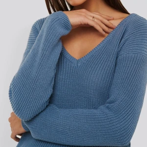 Blå stickad tröja med v-ringning - Säljer en blå stickad tröja med snygg v-ringad hals och långärmade ärmar. Tröjan har en grovstickad struktur som ger en chill och avslappnad vibe. Perfekt att matcha med jeans eller kjol för en cool look.