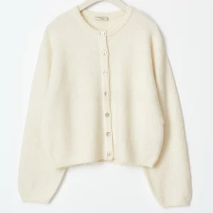 Krämvit kofta från GinaTricot  - Supermysig krämvit kofta från GinaTricot med rund hals och knappar framtill. Koftan är lite oversized och har långa ärmar. Den är väl använd så inte lika fluffig och mjuk som en ny kofta!🫶🏻