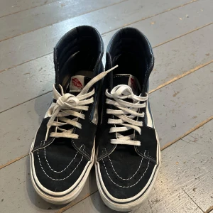Vans sneakers höga blå/svart - Säljer ett par Vans sneakers i klassisk blå och svart färg med vit sula och vit sidostripes. Skorna har högt skaft, rund tå och snörning med vita skosnören. Jag köpte de på vinted, endast använda 1 gång. 