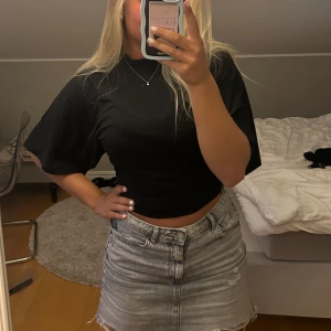 Svart topp - Svart topp som är tajt i midjan med större armar