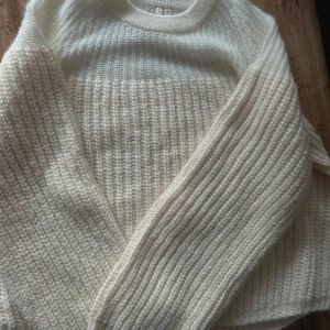 Krämvit stickad tröja från H&M - Säljer en krämvit stickad tröja från Arket storlek S. Tröjan har en loose passform, rund hals och långa ärmar. Den är ribbstickad nedtill och har en tunnare, transparent stickning upptill. Perfekt för dig som gillar mysiga och stilrena plagg.