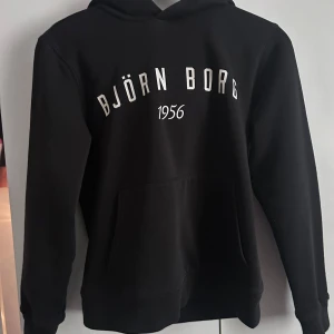 Svart hoodie från Björn Borg - Svart hoodie från Björn Borg. Använd några gånger för nått år sedan men har mest hängt i garderoben, därför säljer jag den❣️
